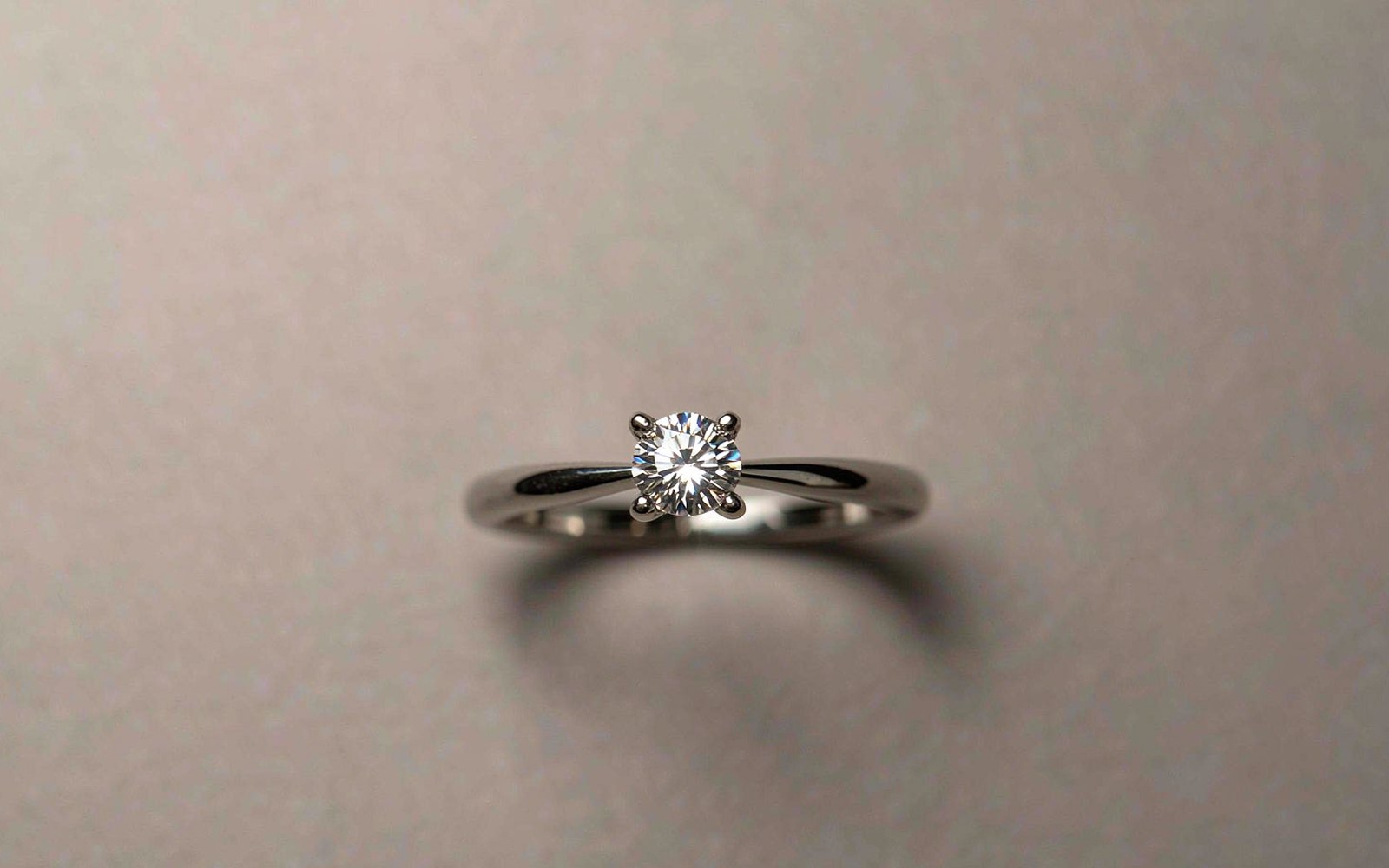 A bright moissanite promise ring on a clean light background